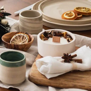 Bougie artisanale fleurie alliant cannelle, fleurs séchées et pot en céramique, ambiance festive et chaleureuse